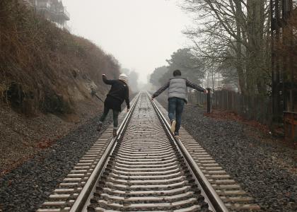 Casal andando pela linha de comboio