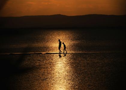 Adult and child walking in the sun