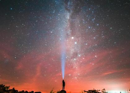 Pessoa sob céu noturno estrelado