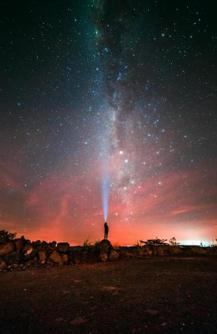 Pessoa sob céu noturno estrelado